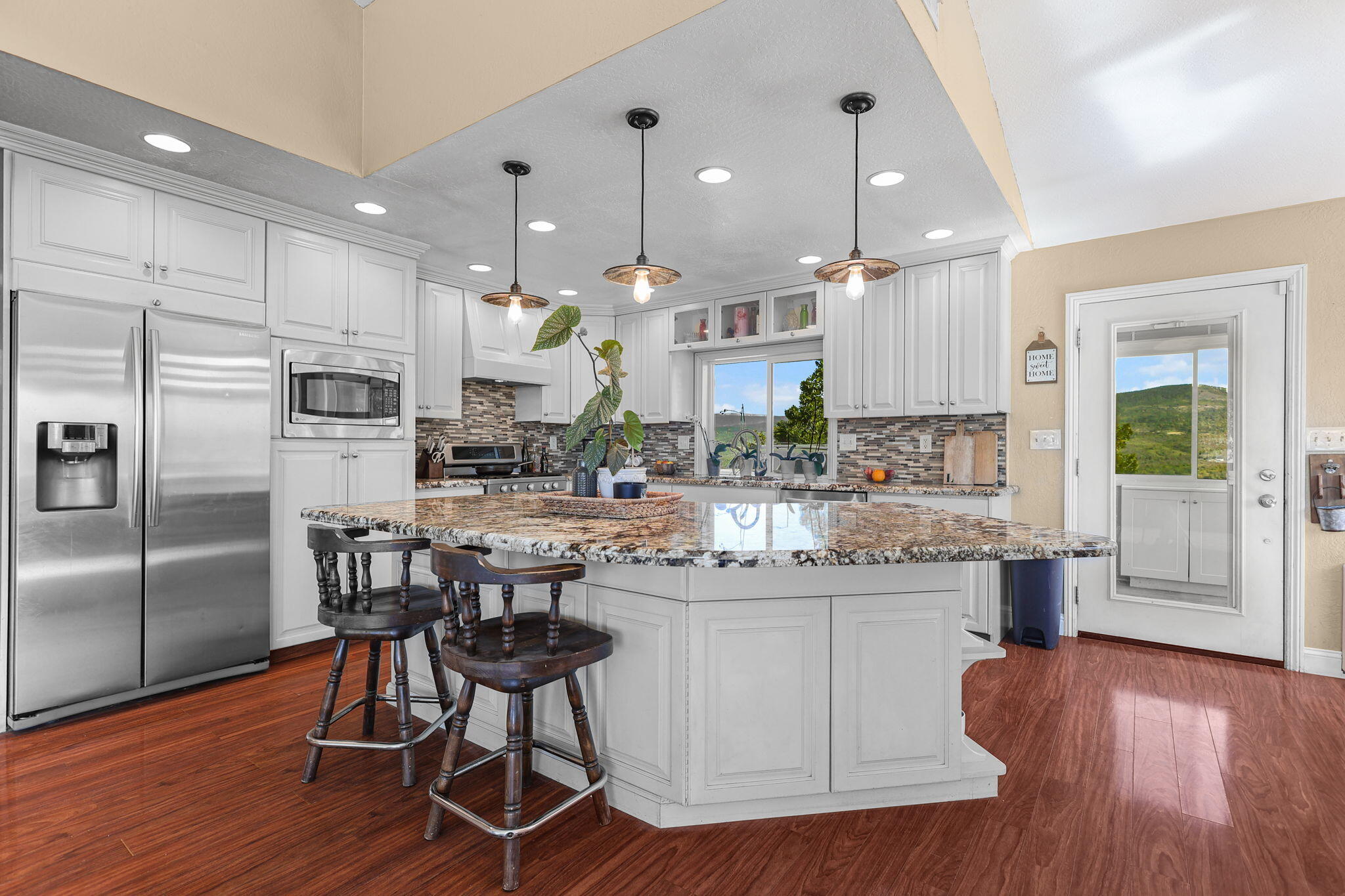 29453 Round Mountain Road Bella Vista, CA 96008 - Photo 7 of 31 a kitchen with stainless steel appliances granite countertop a kitchen island hardwood floor sink and stove