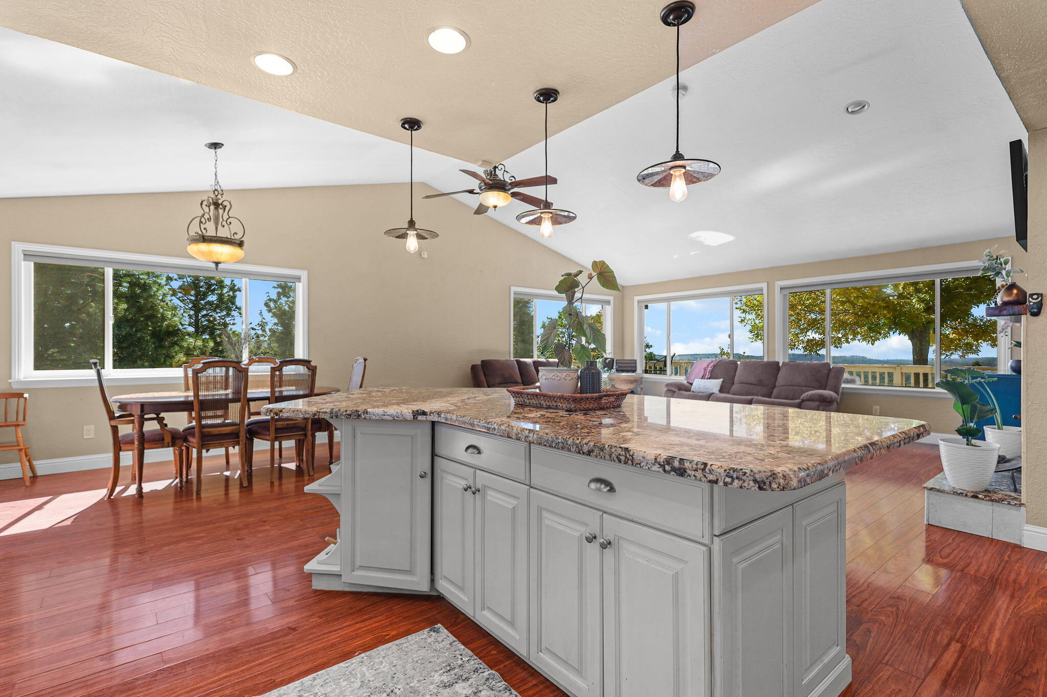 29453 Round Mountain Road Bella Vista, CA 96008 - Photo 9 of 31 a kitchen with stainless steel appliances granite countertop center island wooden floor and a chandelier