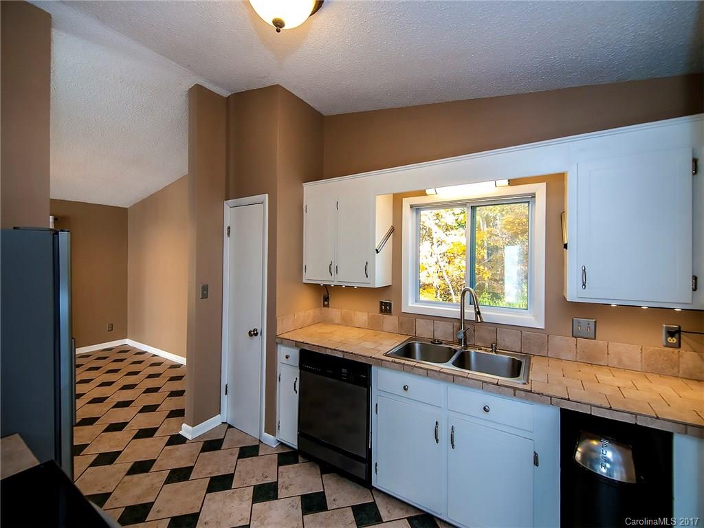 9009 Cebu Court, Unit 9 Tega Cay, SC 29708 - Photo 9 of 24 a kitchen with a sink a refrigerator and cabinets