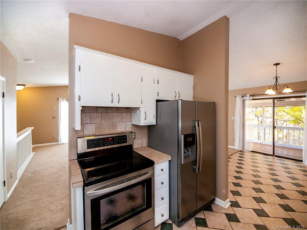9009 Cebu Court, Unit 9 Tega Cay, SC 29708 - Photo 10 of 24 a kitchen with stainless steel appliances a stove a microwave and a refrigerator