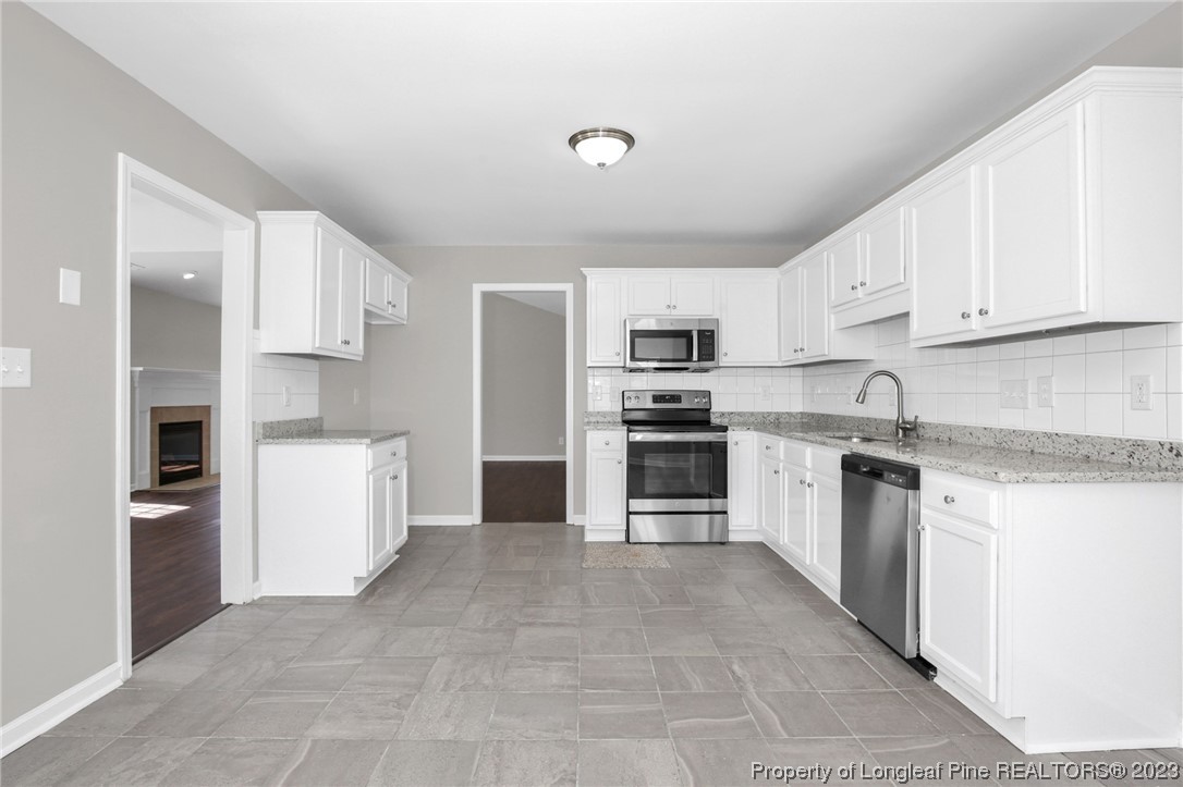 92 Holly Oak Circle Bunnlevel, NC 28323 - Photo 8 of 23 a kitchen with stainless steel appliances granite countertop a refrigerator sink and stove