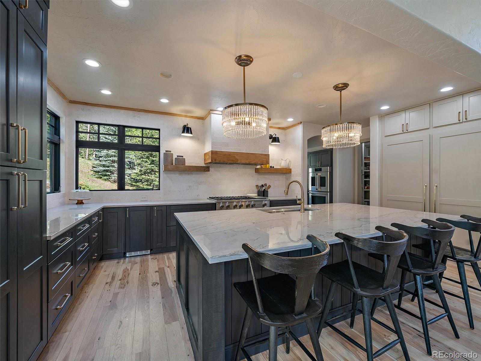 33442 Meadow Mountain Road Evergreen, CO 80439 - Photo 12 of 40 a kitchen with granite countertop a stove a sink a dining table and chairs