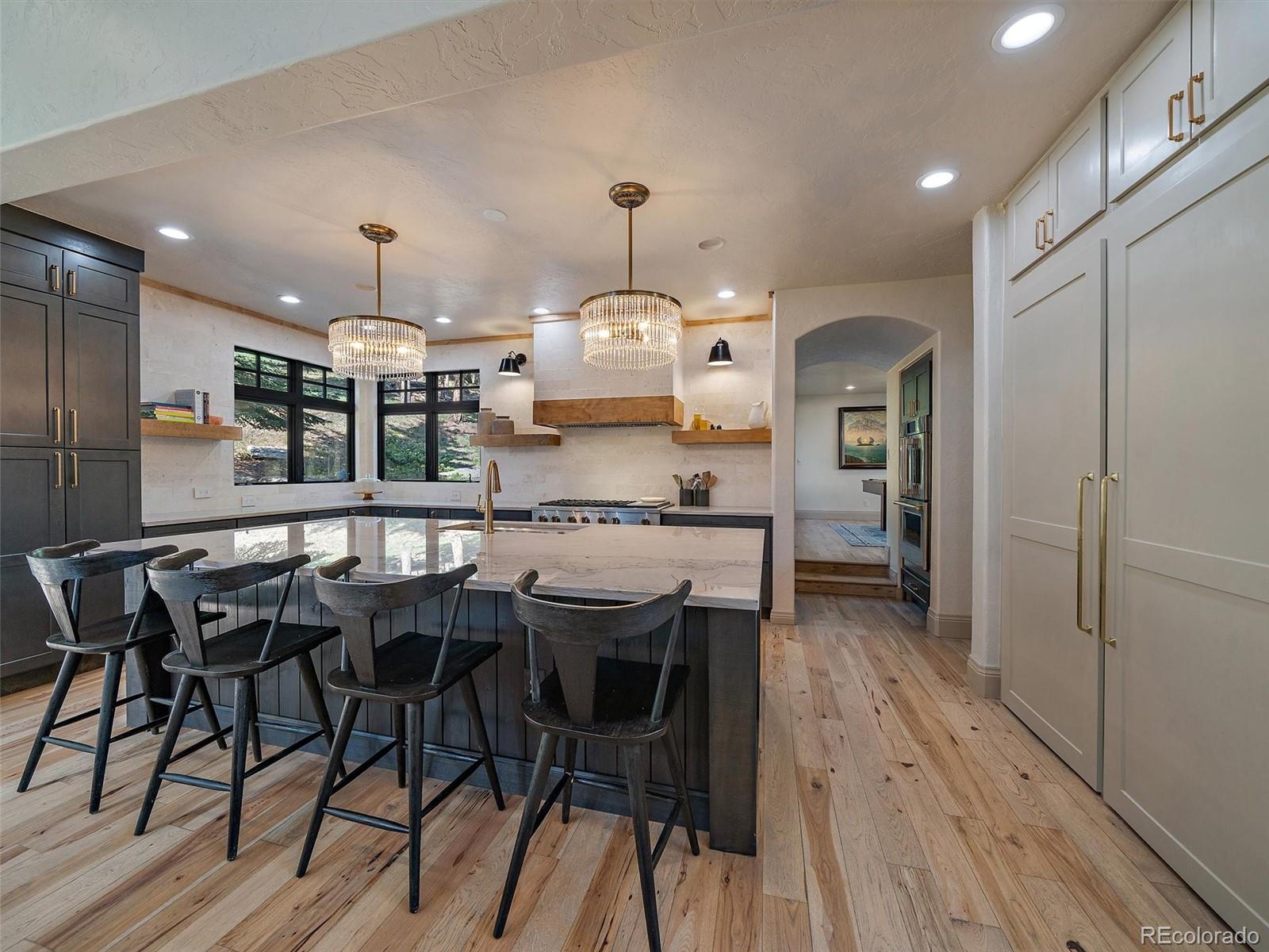 33442 Meadow Mountain Road Evergreen, CO 80439 - Photo 13 of 40 a kitchen with stainless steel appliances a dining table chairs stove and cabinets