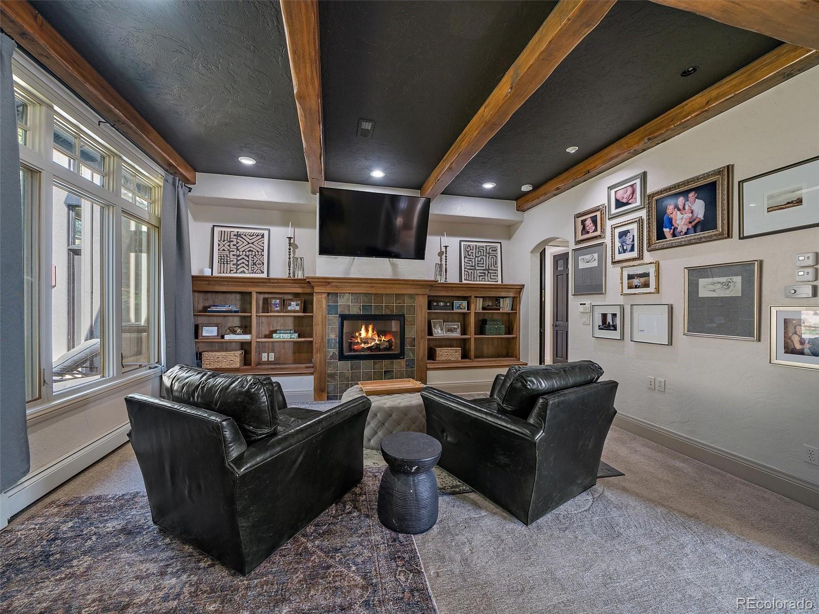 33442 Meadow Mountain Road Evergreen, CO 80439 - Photo 17 of 40 a living room with furniture a fireplace and a large window