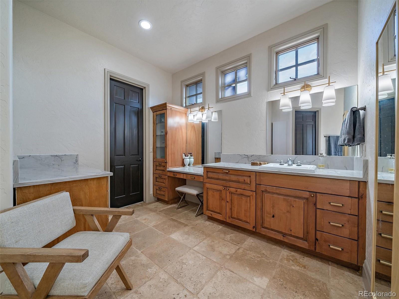 33442 Meadow Mountain Road Evergreen, CO 80439 - Photo 18 of 40 a spacious bathroom with a granite countertop sink mirror and bathtub