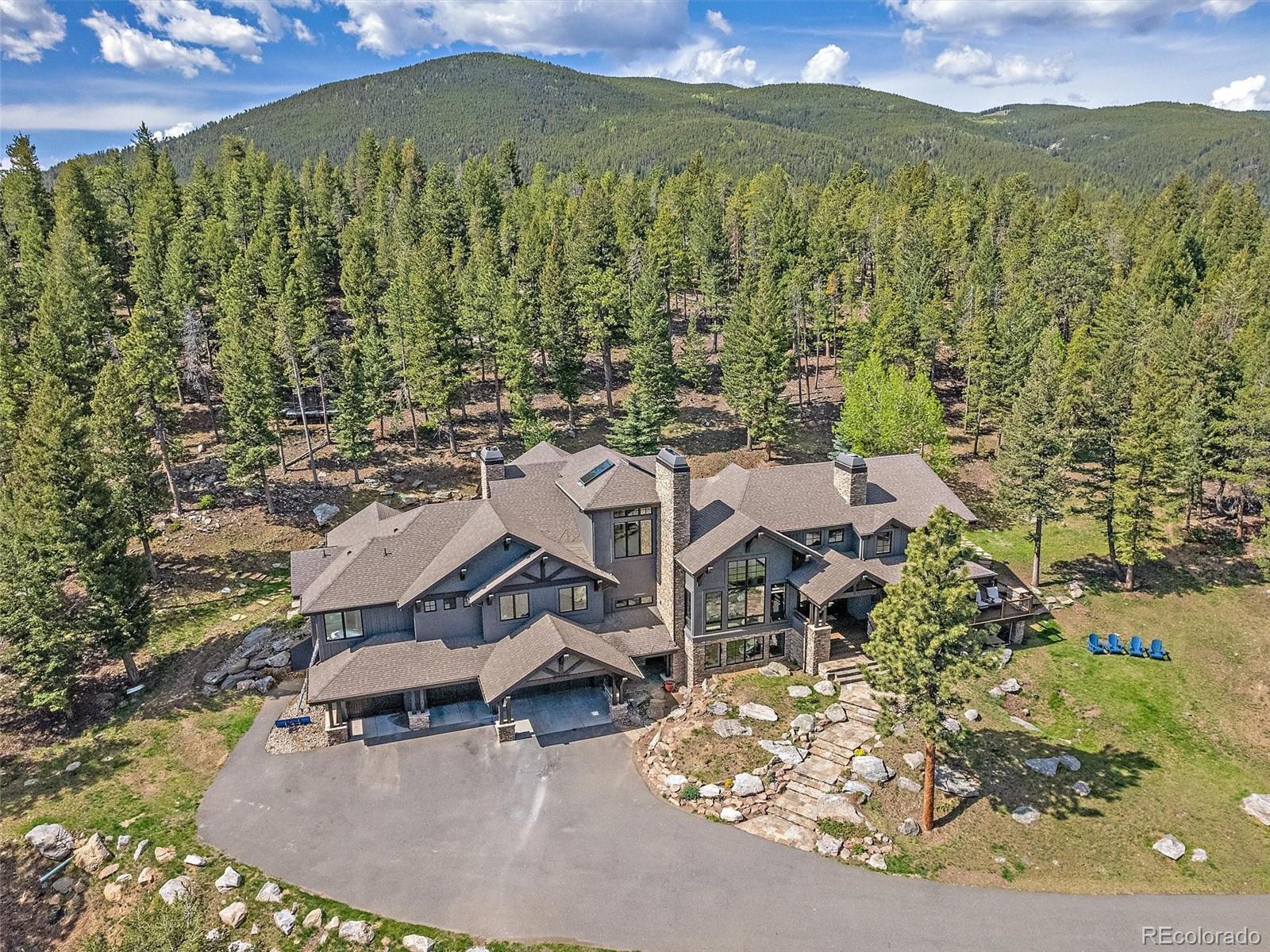 33442 Meadow Mountain Road Evergreen, CO 80439 - Photo 2 of 40 an aerial view of a house with a yard swimming pool and mountain view
