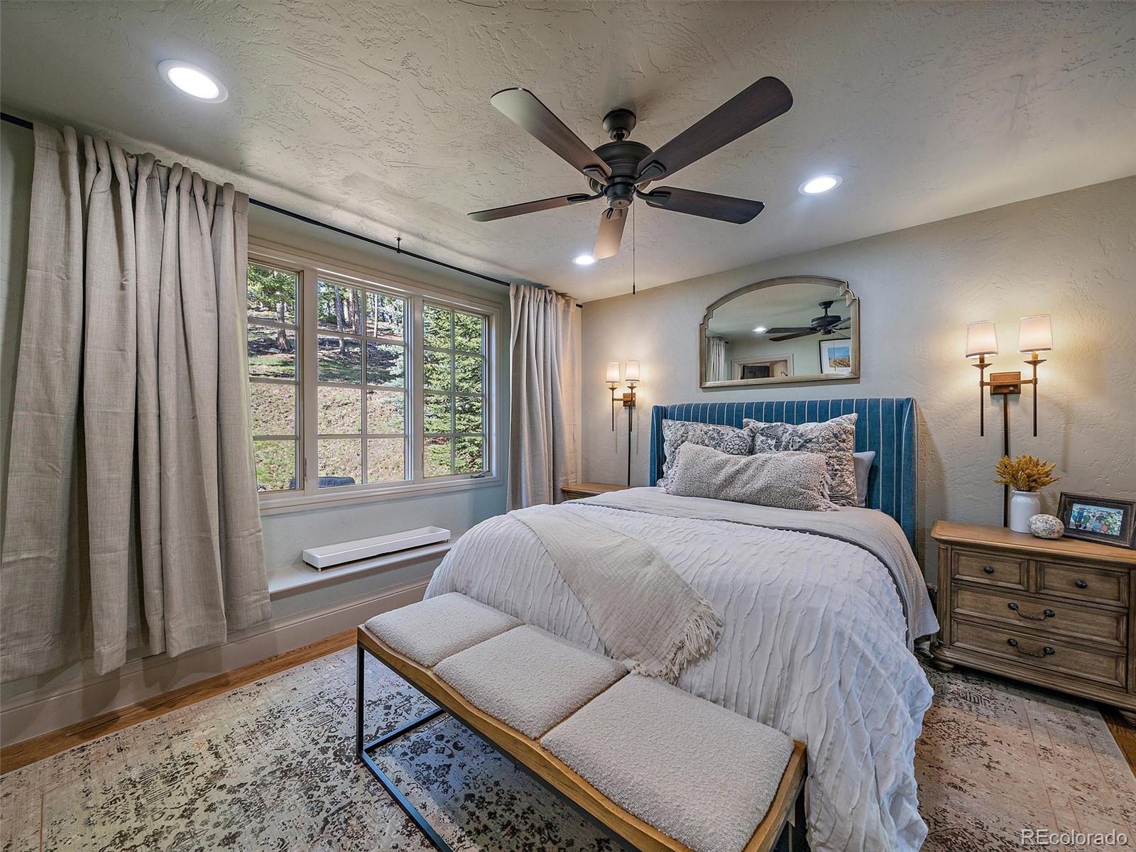 33442 Meadow Mountain Road Evergreen, CO 80439 - Photo 21 of 40 a bedroom with a bed and wooden floor