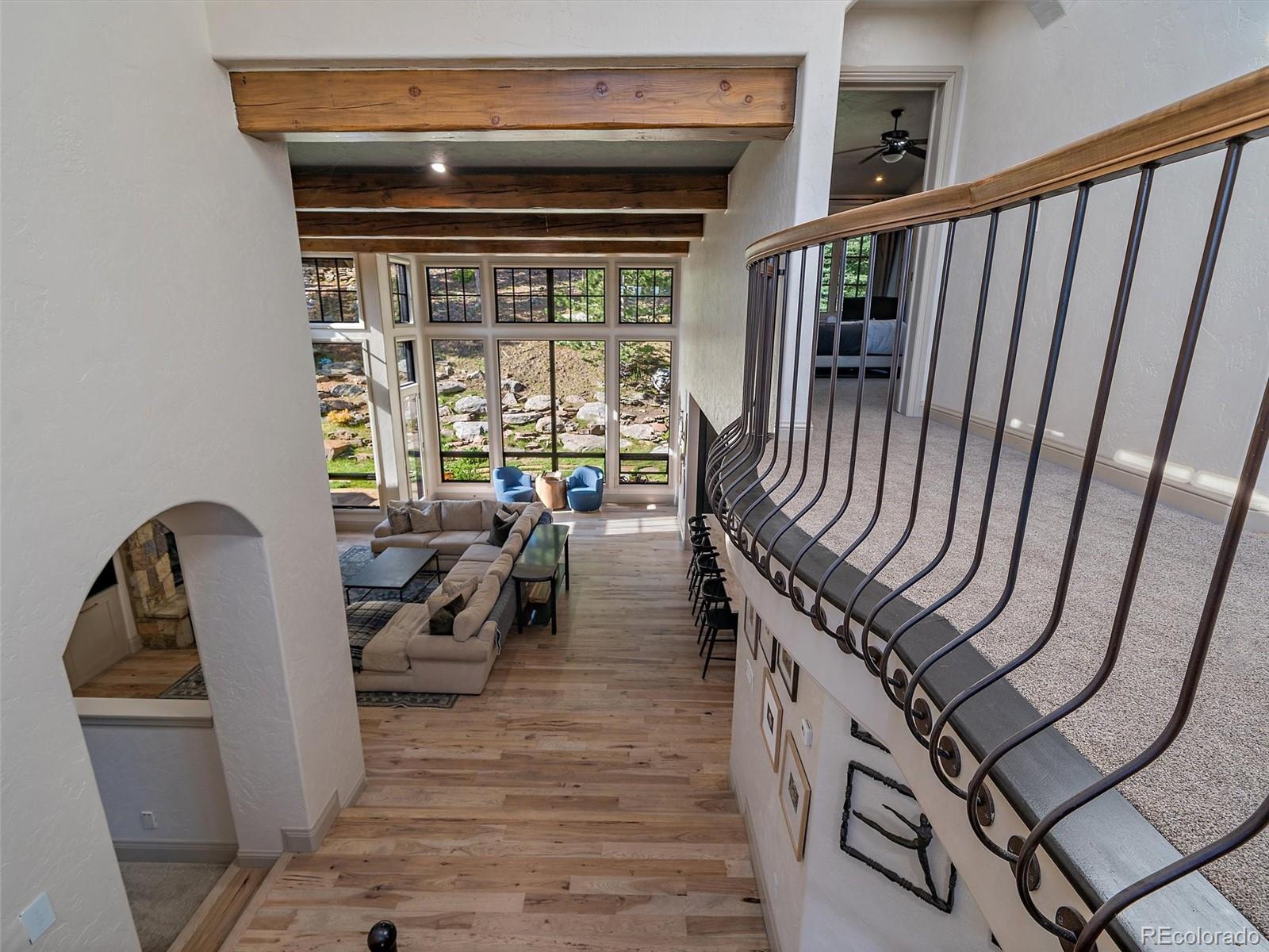 33442 Meadow Mountain Road Evergreen, CO 80439 - Photo 22 of 40 a view of a hallway with wooden floor and furniture