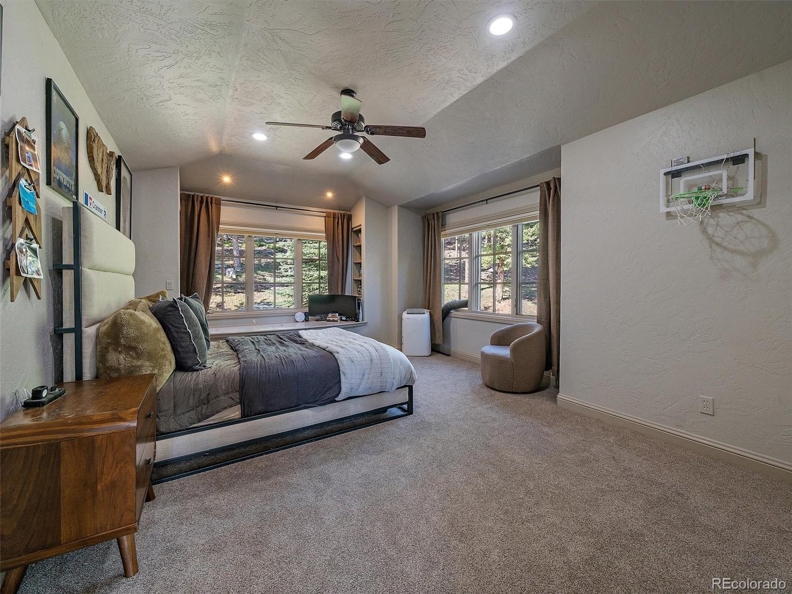 33442 Meadow Mountain Road Evergreen, CO 80439 - Photo 25 of 40 a spacious bedroom with a bed and window