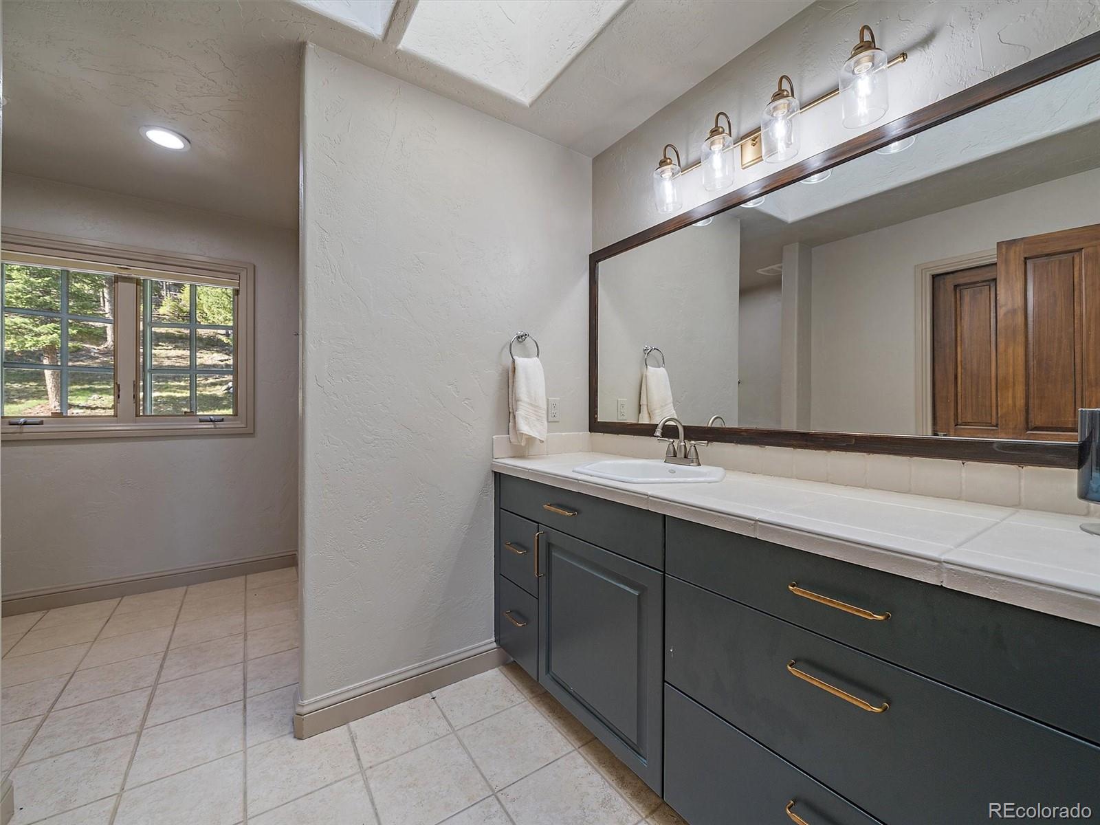 33442 Meadow Mountain Road Evergreen, CO 80439 - Photo 29 of 40 a bathroom with a sink and a mirror