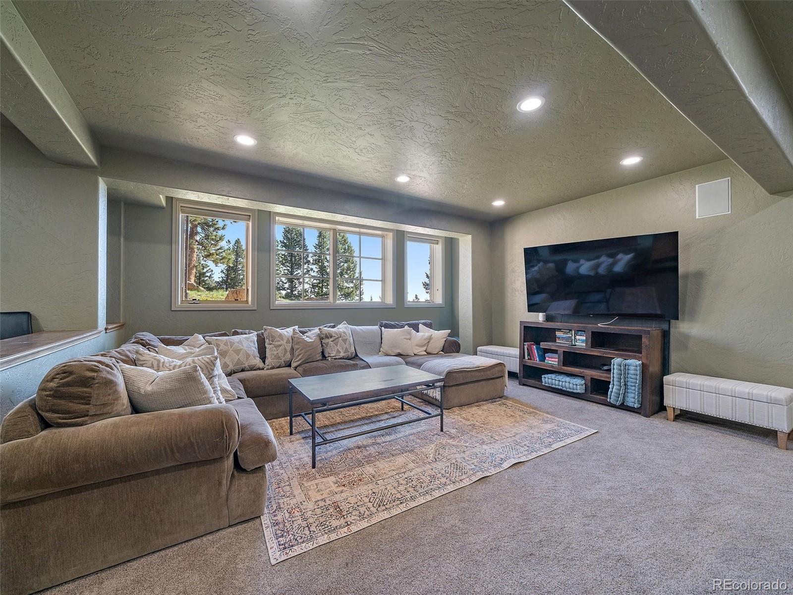 33442 Meadow Mountain Road Evergreen, CO 80439 - Photo 30 of 40 a living room with furniture and a flat screen tv