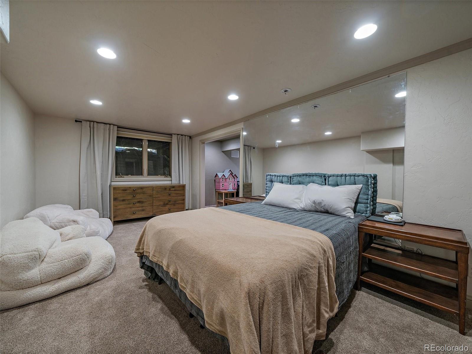 33442 Meadow Mountain Road Evergreen, CO 80439 - Photo 33 of 40 a spacious bedroom with a bed and a couch