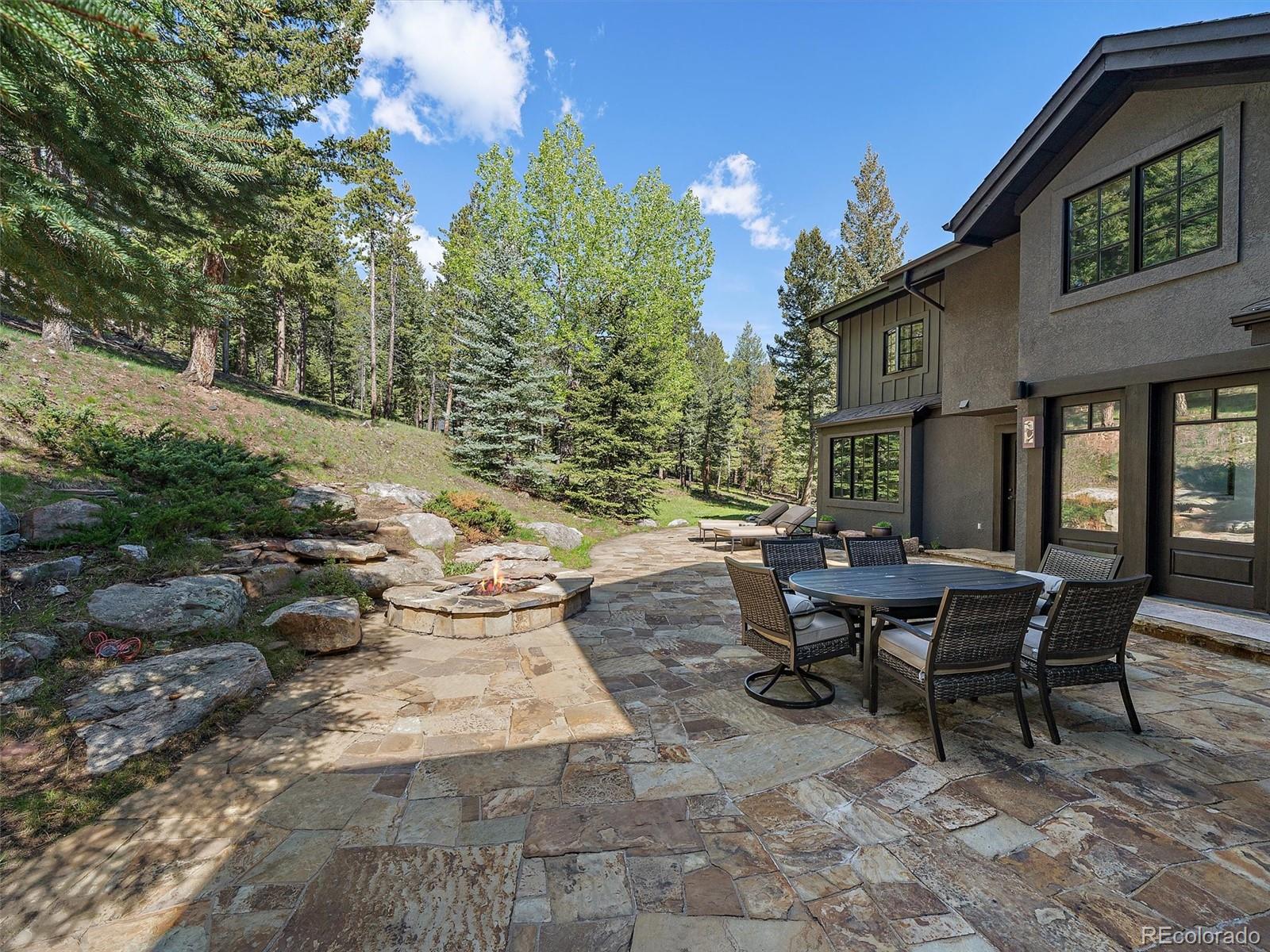 33442 Meadow Mountain Road Evergreen, CO 80439 - Photo 35 of 40 a view of a patio with table and chairs and potted plants