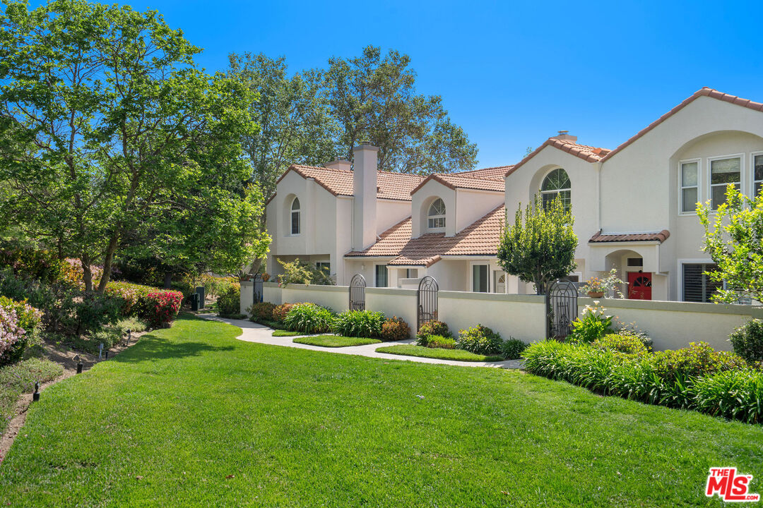 a front view of a house with a garden and plants