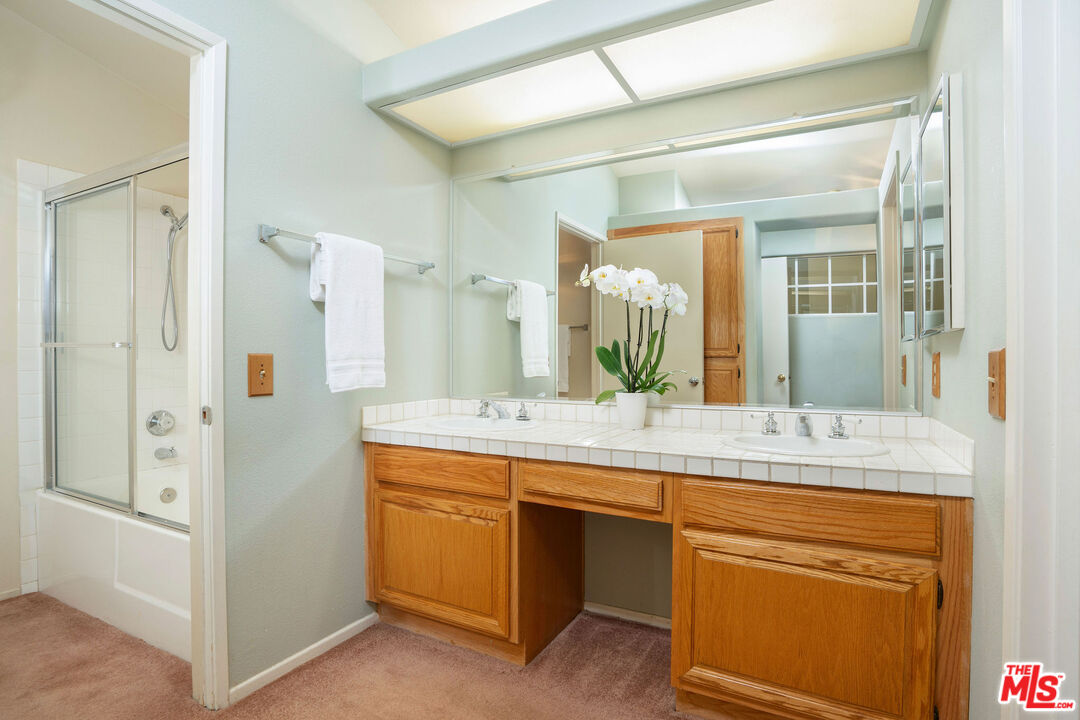 22211 Frontier Place Chatsworth, CA 91311 - Photo 15 of 26 a bathroom with a granite countertop sink and a mirror