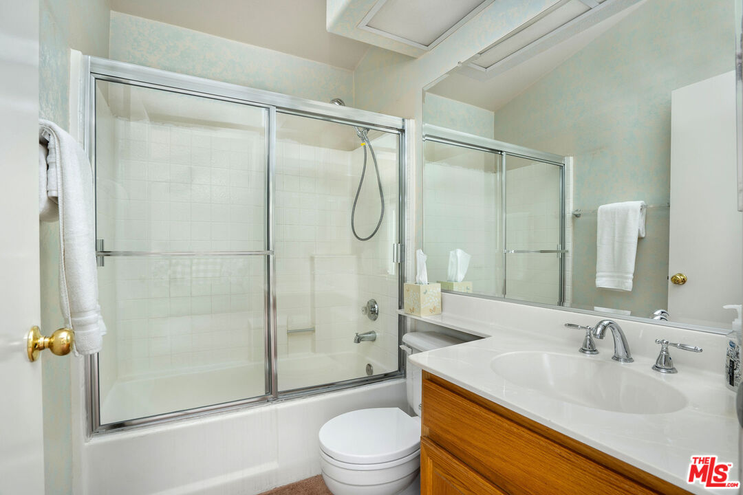 22211 Frontier Place Chatsworth, CA 91311 - Photo 19 of 26 a bathroom with a granite countertop sink toilet and shower