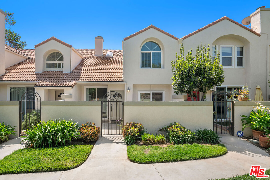 22211 Frontier Place Chatsworth, CA 91311 - Photo 2 of 26 a front view of a house with a garden
