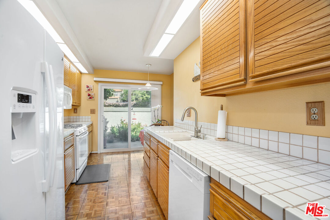 22211 Frontier Place Chatsworth, CA 91311 - Photo 5 of 26 a kitchen with a sink and large window