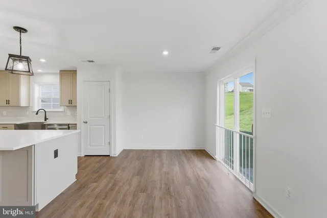 a view of a kitchen sink and wooden floor