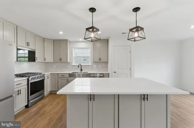 a kitchen with a center island and stainless steel appliances