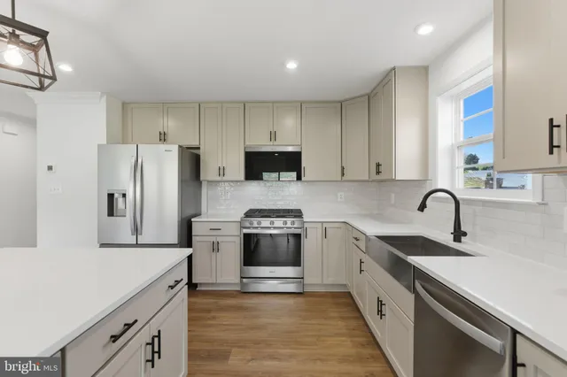 a kitchen with white cabinets and stainless steel appliances