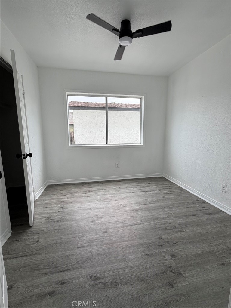 304 West Cedar Street Compton, CA 90220 - Photo 5 of 9 an empty room with wooden floor and windows