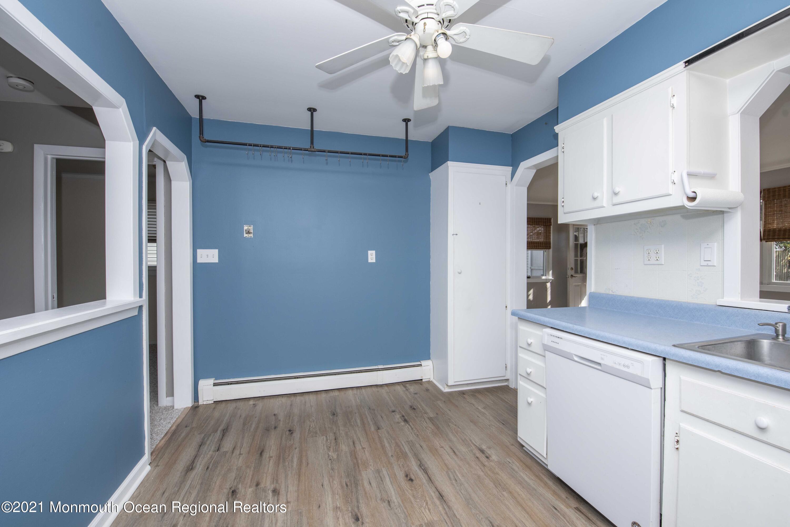 3208 Kickapoo Avenue Point Pleasant, NJ 08742 - Photo 10 of 23 a kitchen with kitchen island white cabinets and wooden floor