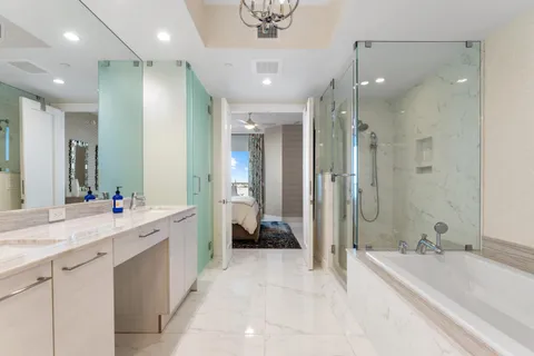 a bathroom with a granite countertop sink toilet mirror and shower