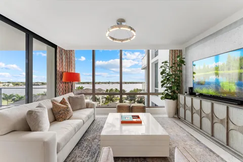 a kitchen with stainless steel appliances granite countertop a stove top oven a sink dishwasher a dining table and chairs with wooden floor