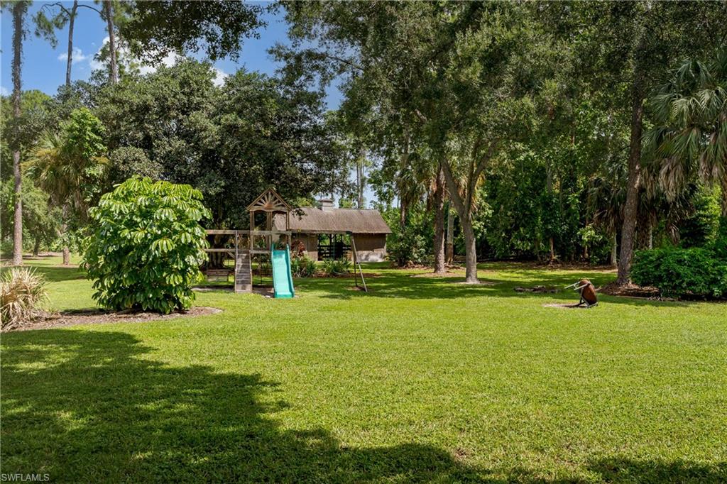 3301 31st Avenue Southwest Naples, FL 34117 - Photo 17 of 22 a view of a house with swimming pool and sitting area