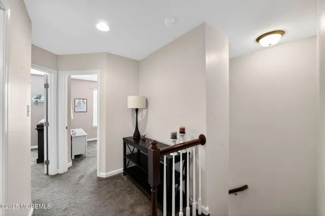 a view of a hallway with closet and a bathroom