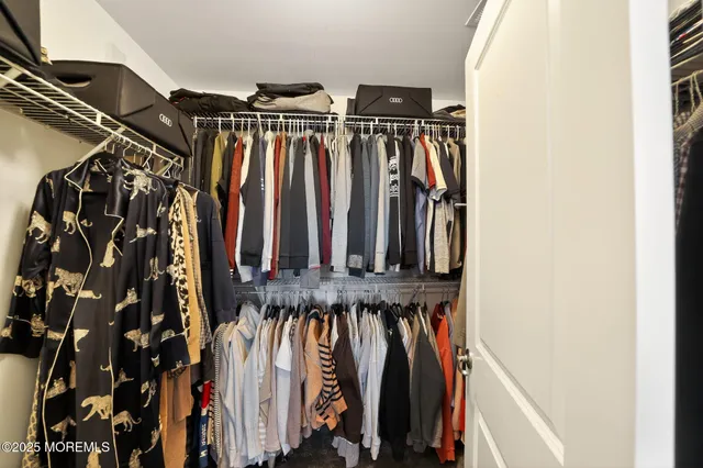 a view of walk in closet with clothes and shoes