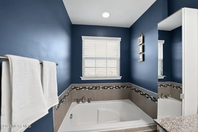 a bathroom with a bathtub and a window