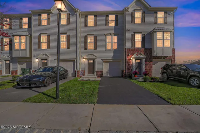 a front view of a house with a garden and parking