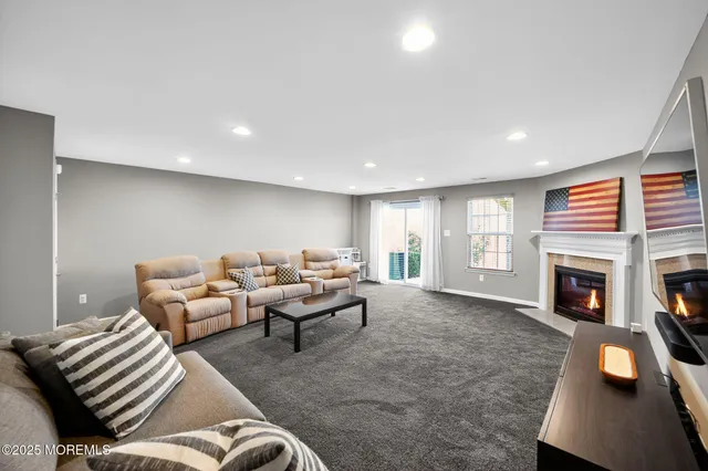 a living room with furniture a fireplace and a window