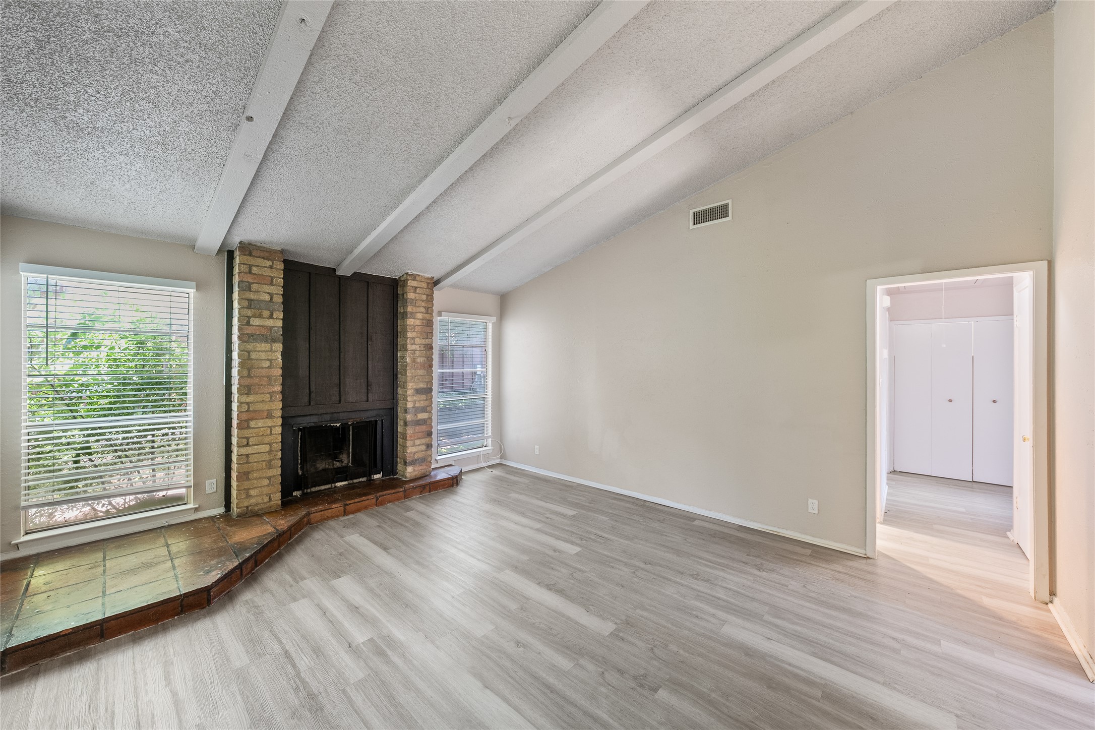 1111 West Rundberg Lane Austin, TX 78758 - Photo 3 of 16 A striking brick fireplace and vaulted ceilings define this inviting living area.