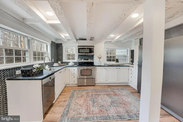 a kitchen with a sink stainless steel appliances and cabinets