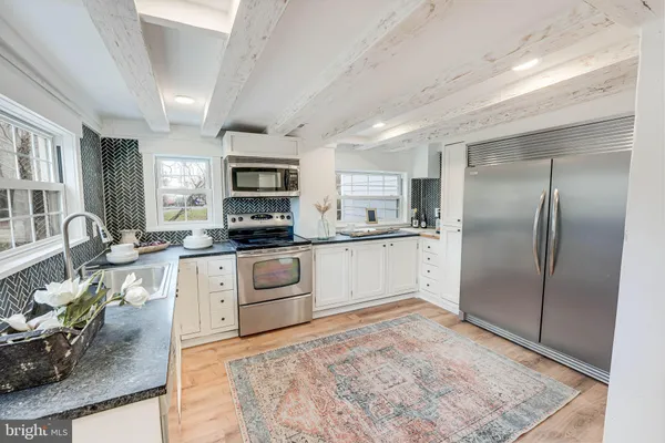 a kitchen with stainless steel appliances granite countertop a refrigerator stove microwave and sink