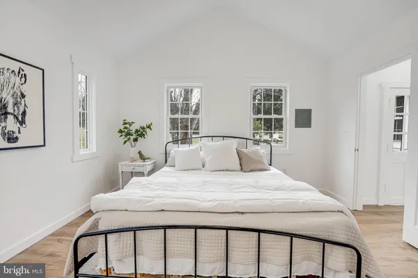 a bedroom with a bed and wooden floor