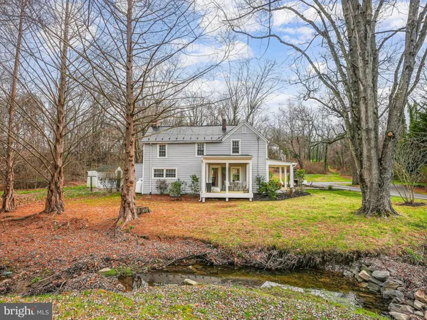 a front view of a house with a yard and lake view