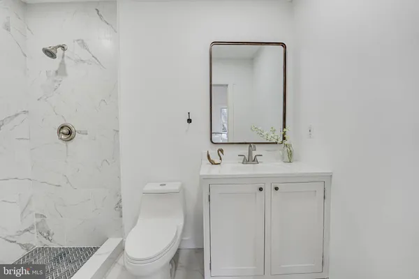 a bathroom with a toilet a sink a mirror and vanity