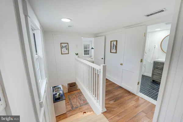 a view of a hallway with wooden floor and staircase