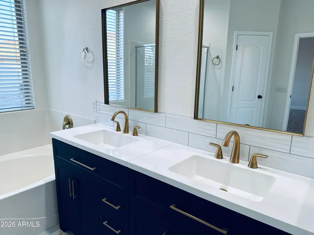 a bathroom with double sink and two mirror