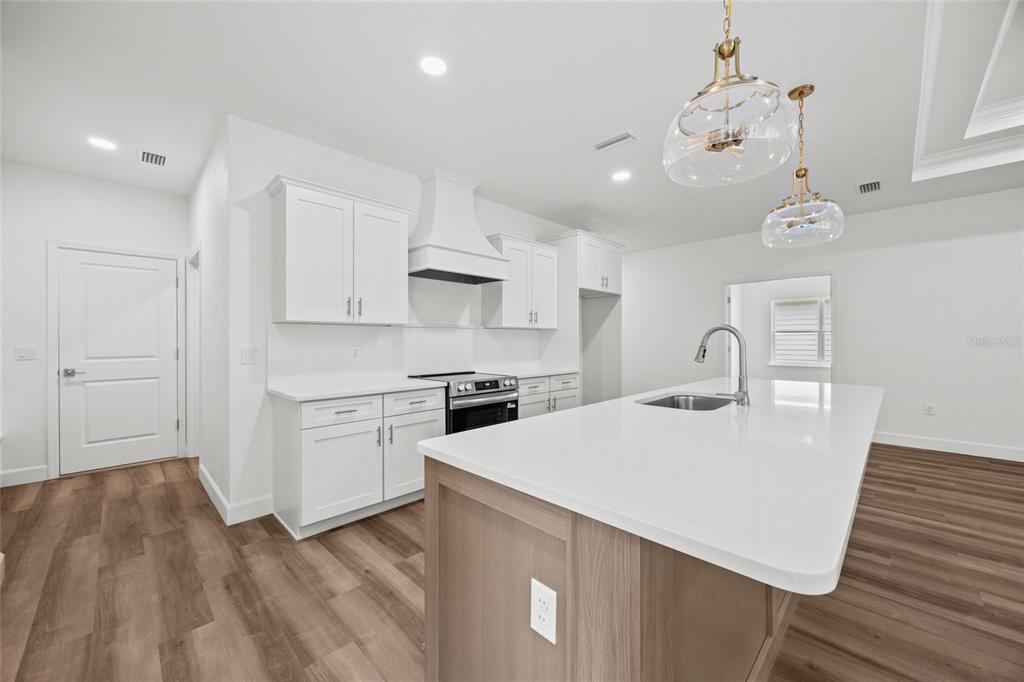 1099 Southwest 66th Terrace Gainesville, FL 32607 - Photo 23 of 35 a kitchen with a sink a stove a refrigerator and cabinets