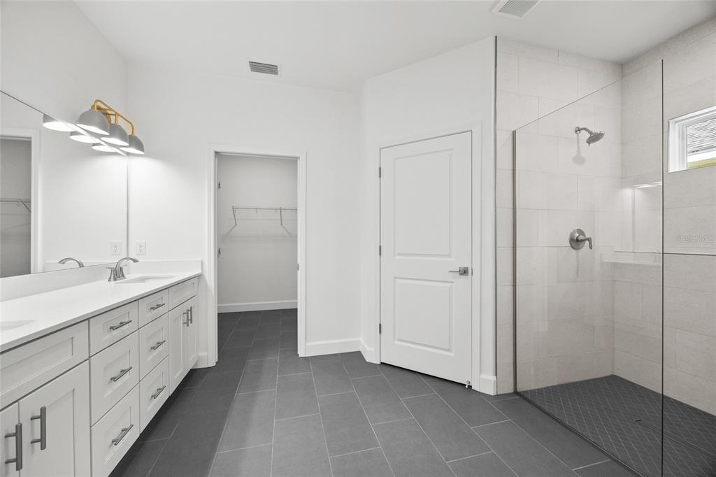 1099 Southwest 66th Terrace Gainesville, FL 32607 - Photo 8 of 35 a bathroom with a double vanity sink and mirror