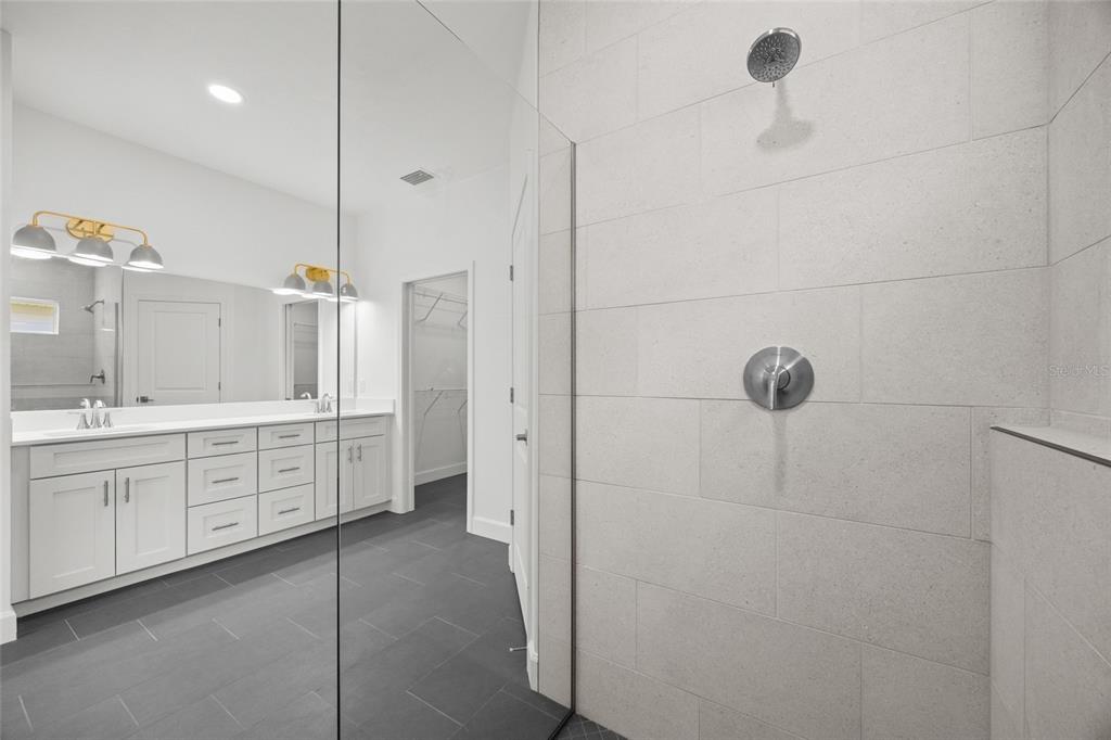 1099 Southwest 66th Terrace Gainesville, FL 32607 - Photo 9 of 35 a large bathroom with a double vanity sink a mirror and shower