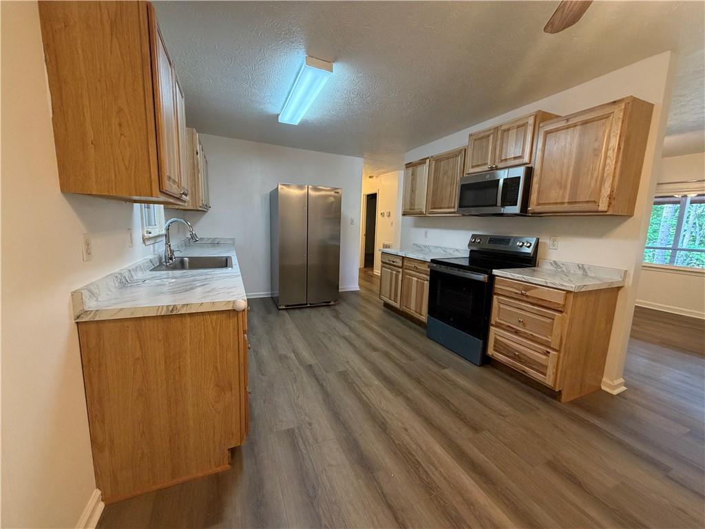 86 Robert Jones Road Dawsonville, GA 30534 - Photo 6 of 19 a kitchen with stainless steel appliances granite countertop a refrigerator a stove top oven a sink dishwasher and wooden floor