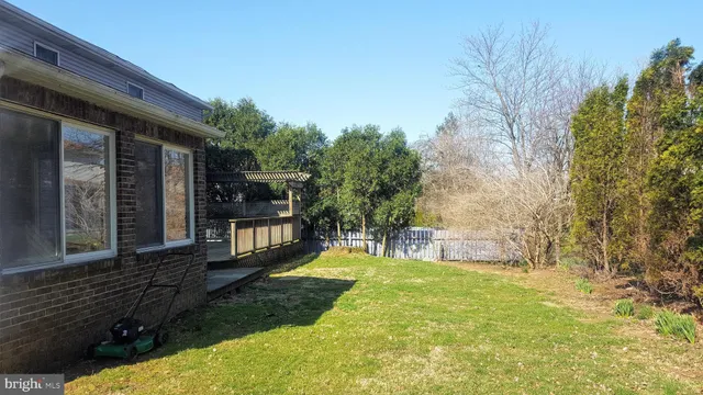 a backyard of a house with swimming pool and wooden fence