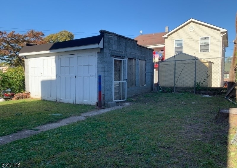 76 Jasper Street Paterson, NJ 07522 - Photo 11 of 12 a view of backyard with wooden fence and large trees
