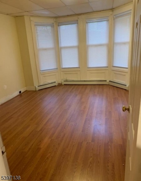 76 Jasper Street Paterson, NJ 07522 - Photo 6 of 12 an empty room with wooden floor and windows